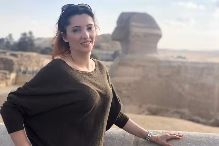 Tour guest by the Great Sphinx of Giza on a private Cairo pyramids tour with lunch and optional camel ride