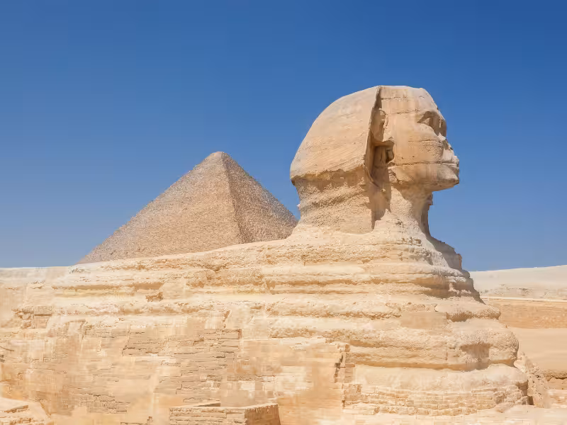 Great Sphinx of Giza with pyramid backdrop under blue sky, highlight of Wonders of the Pharaohs tour