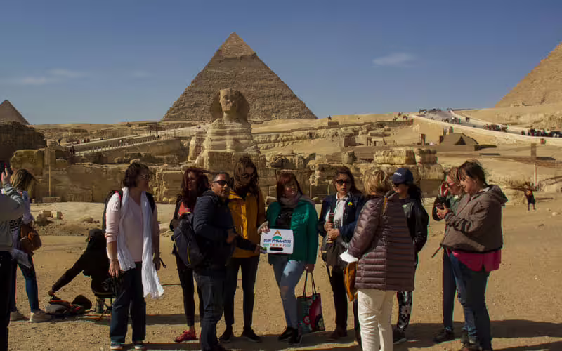 Tour group at the Great Sphinx with Giza Pyramids behind on a full-day Cairo pyramids guided tour