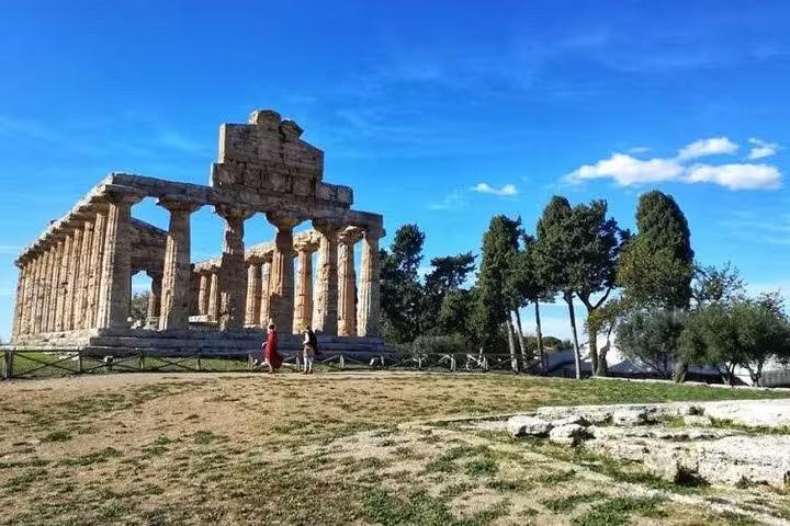 Magnificent Greek temple ruins under a clear blue sky, part of the Paestum Temples tour with farm experience from Sorrento.
