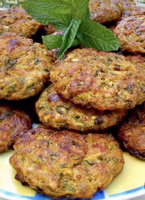 Savory Greek zucchini fritters garnished with fresh mint, highlighting authentic flavors at the Athens Ancient Greece Symposium Lunch.