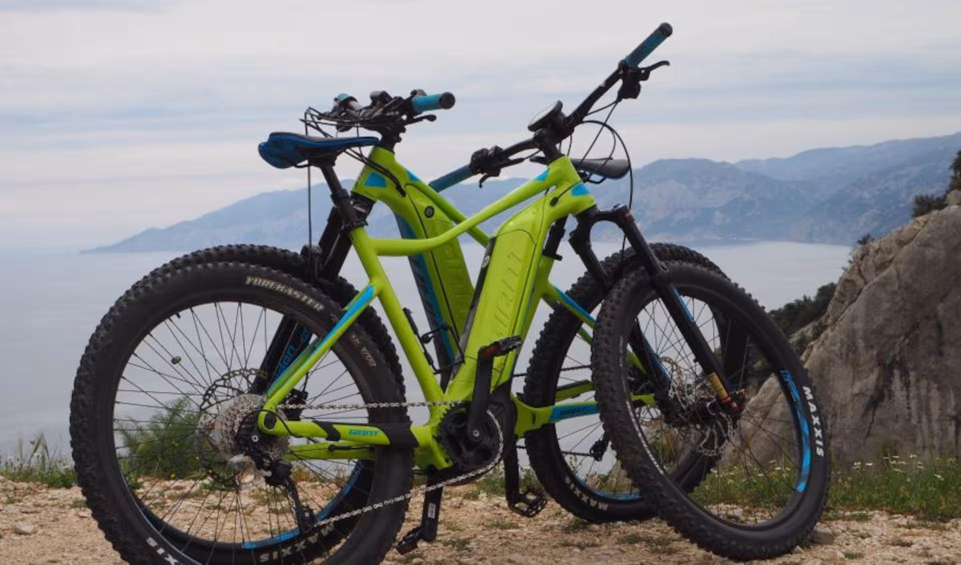 Two vibrant green e-bikes with mountain views in Sardinia, perfect for exploring scenic landscapes from Olbia.