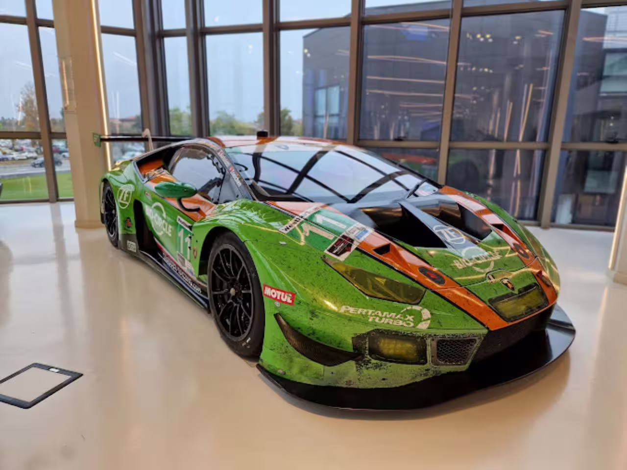 Sleek green Lamborghini race car displayed at Museo Lamborghini, perfect for a thrilling simulator experience.