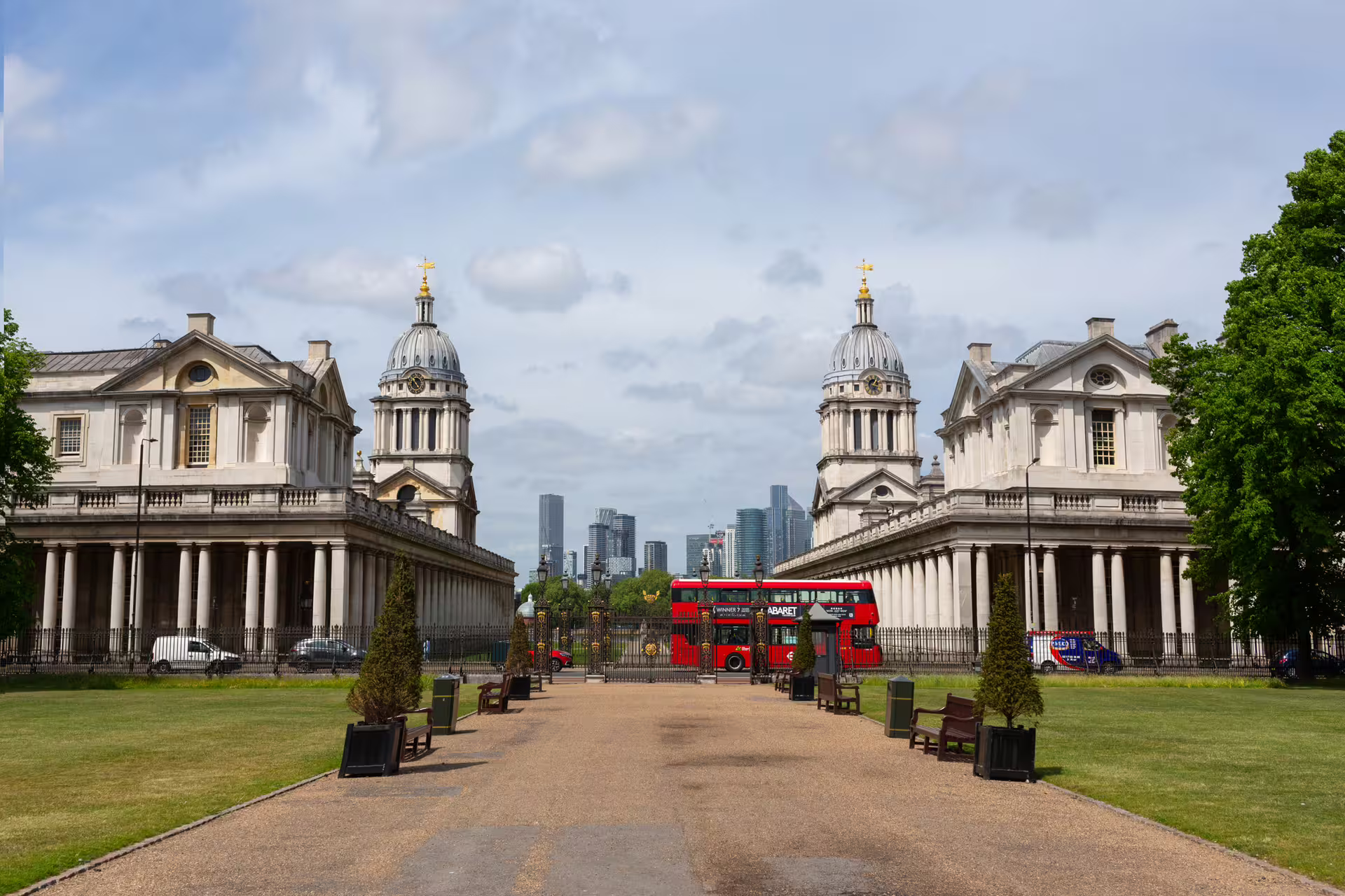Greenwich twin domes by the park with red double-decker bus, London walking tour highlight with audioguide