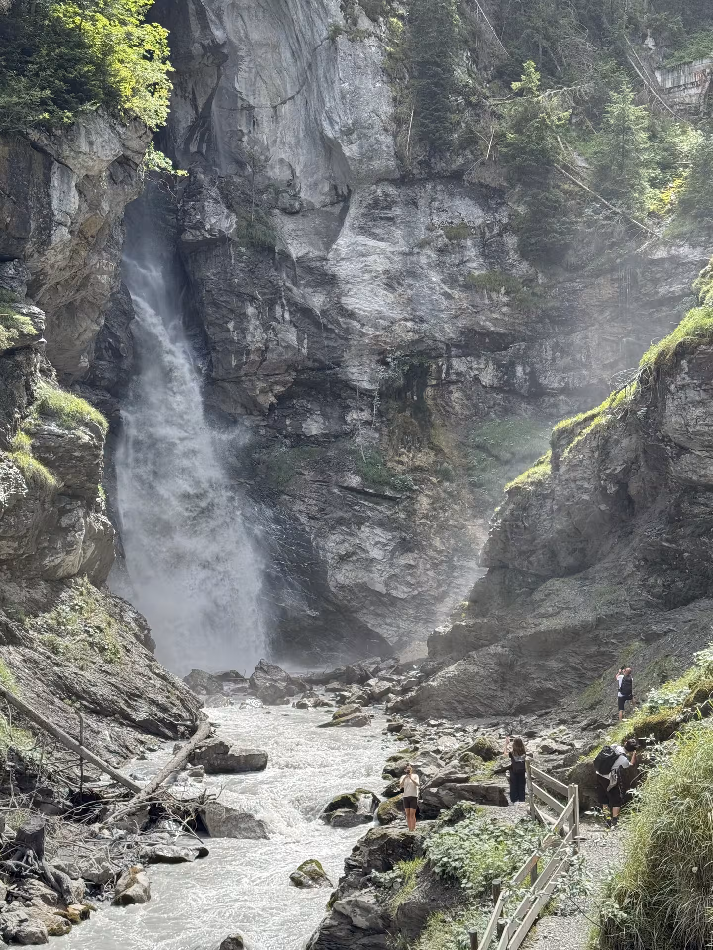 Powerful waterfall in rocky canyon with trail viewpoint on Griesalp UNESCO alpine valley E-bike tour