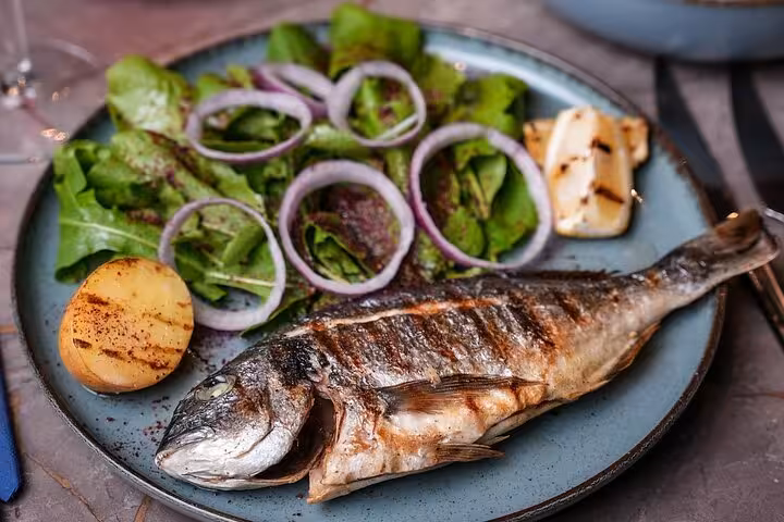Grilled sea bass with salad served on Istanbul Bosphorus dinner cruise, private table Turkish night experience
