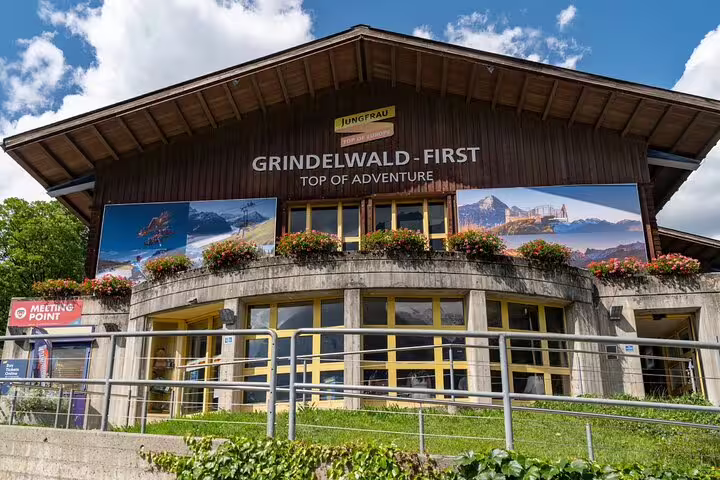 Grindelwald First Top of Adventure building with vibrant signage and meeting point.