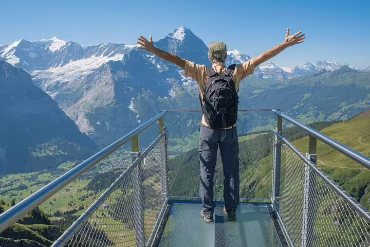 Traveler embraces the stunning alpine scenery at Grindelwald First, a highlight of the Zurich private day tour.