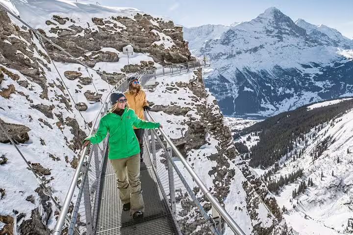 Tourists enjoy breathtaking views on the Grindelwald First cliff walk during a private day tour from Zurich.
