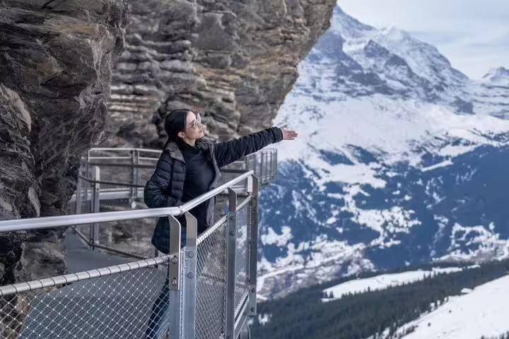 Woman enjoying scenic views from Grindelwald First cliff walk on private day tour from Zurich.