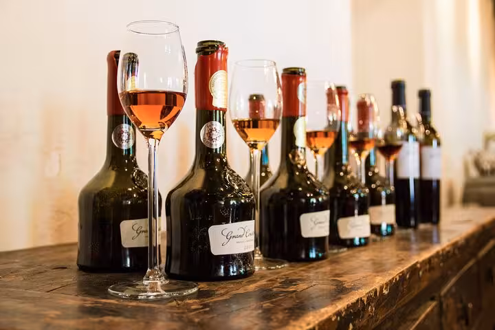 A row of wine bottles and glasses at Groot Constantia, highlighting the rich selection at this renowned South African winery.