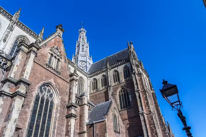 Exterior of Grote Kerk St Bavo in Haarlem under blue sky, landmark on 2-hour history highlights walking tour