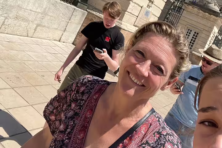 Smiling group using smartphones on a Dijon self-guided e-scavenger hunt, exploring historic streets at own pace