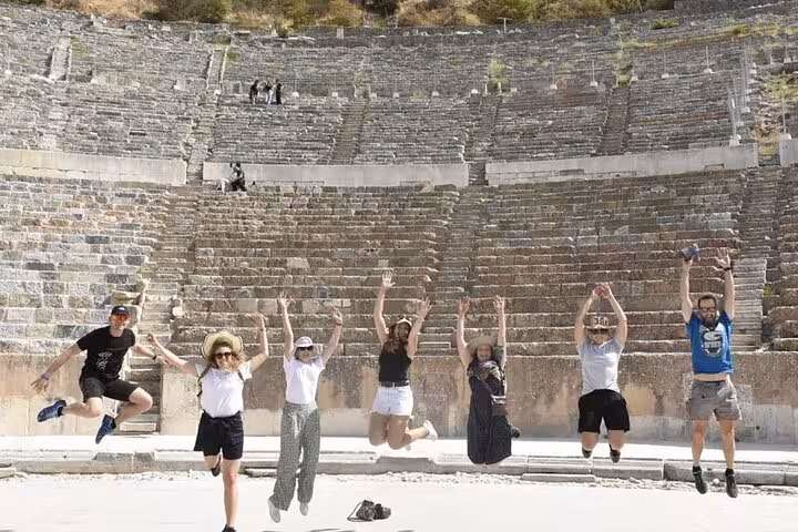 Group jumping at the Great Theatre of Ephesus on a private cruise shore tour from Kusadasi, Turkey