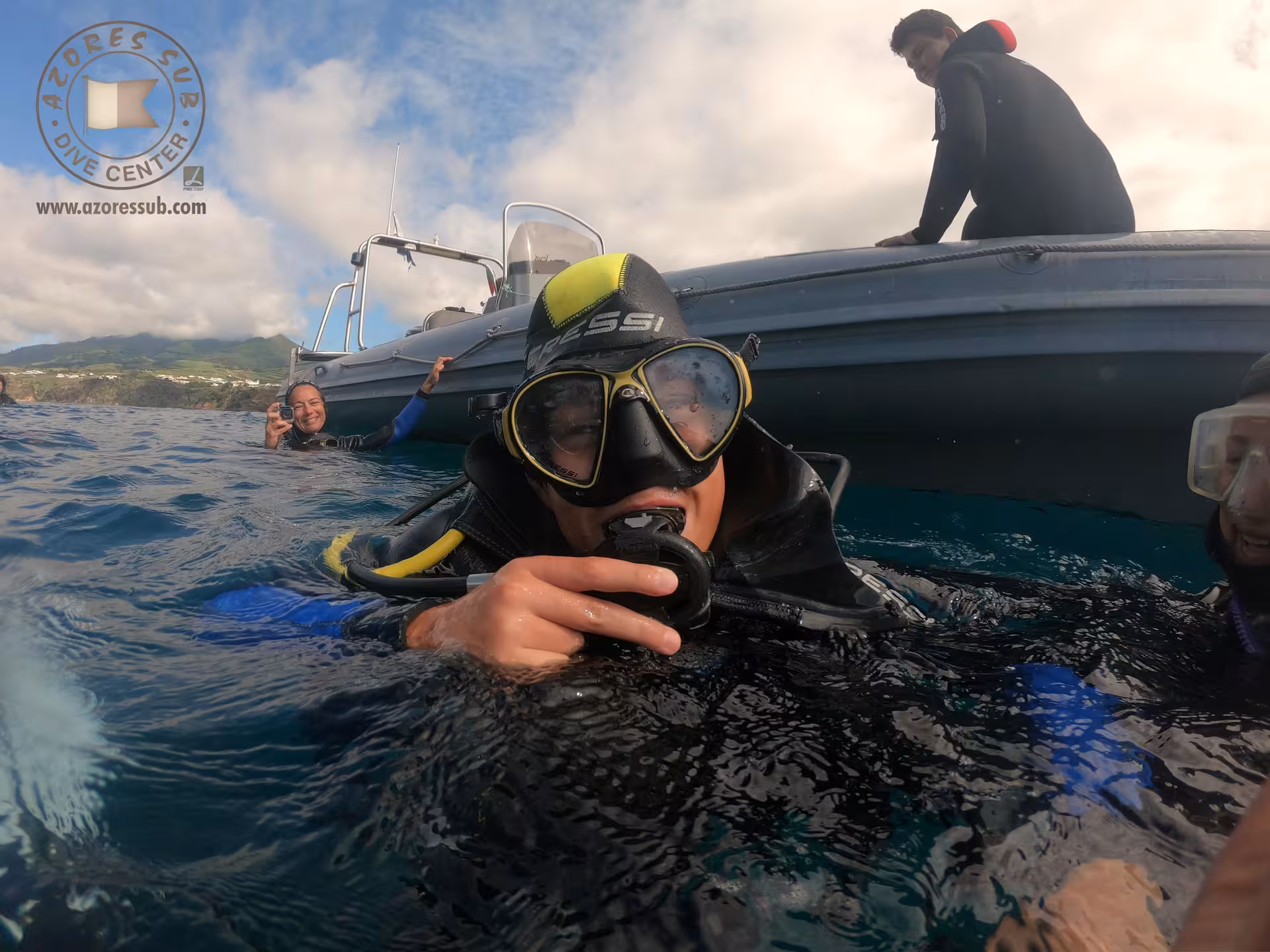Group in the ocean beside a boat, ready for a pool and sea baptism tour with guided support and calm waters