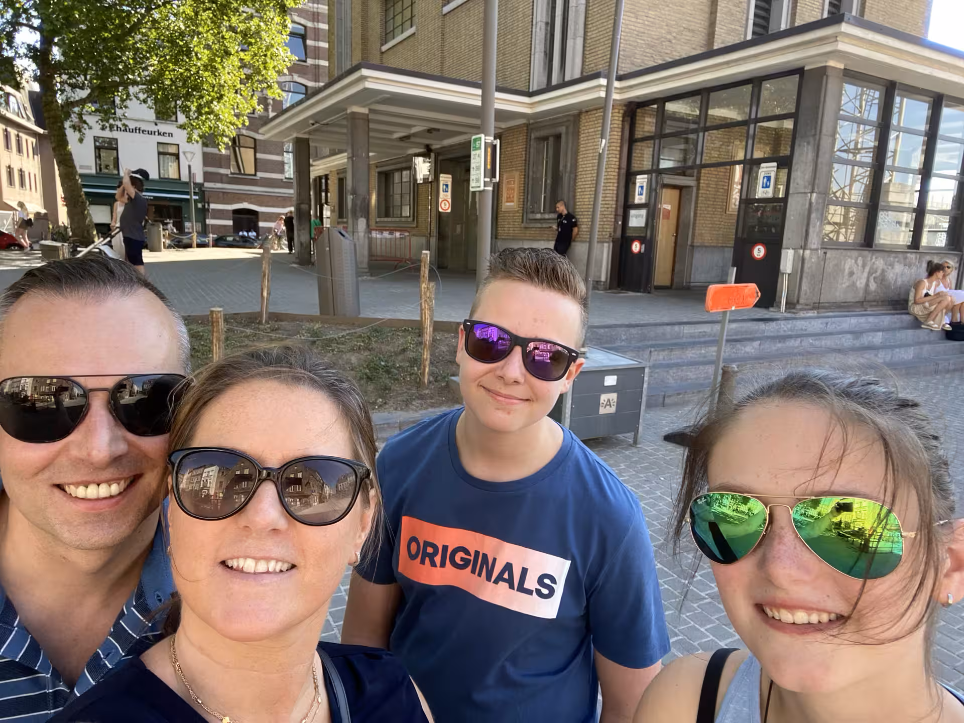 Group selfie in Antwerp while playing a self-paced e-scavenger hunt, exploring city sights with a mobile app