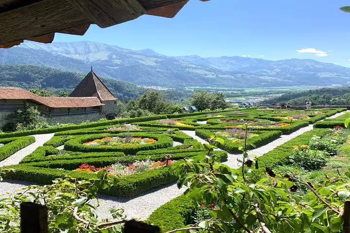 Lush gardens of Gruyères Castle with scenic mountain views, featured in Bern's small group tour.
