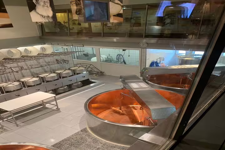Cheese-making facility with large copper vats, part of the Gruyères cheese tasting tour in Bern.