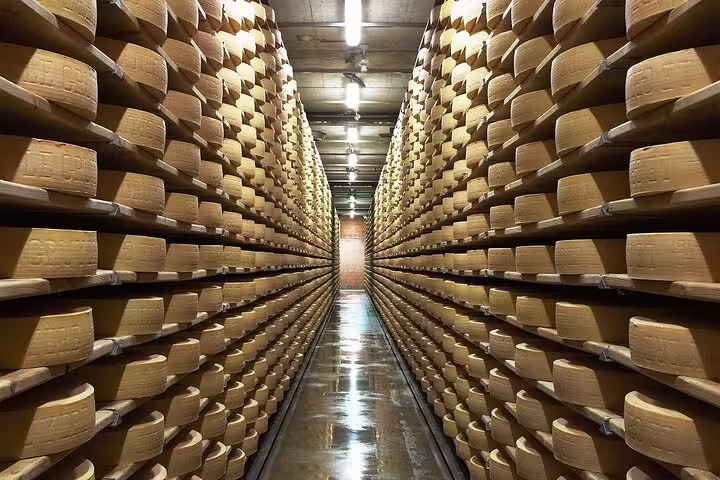 Rows of aging cheese wheels in a Gruyères cellar, showcasing the artisanal process on a private tasting tour.