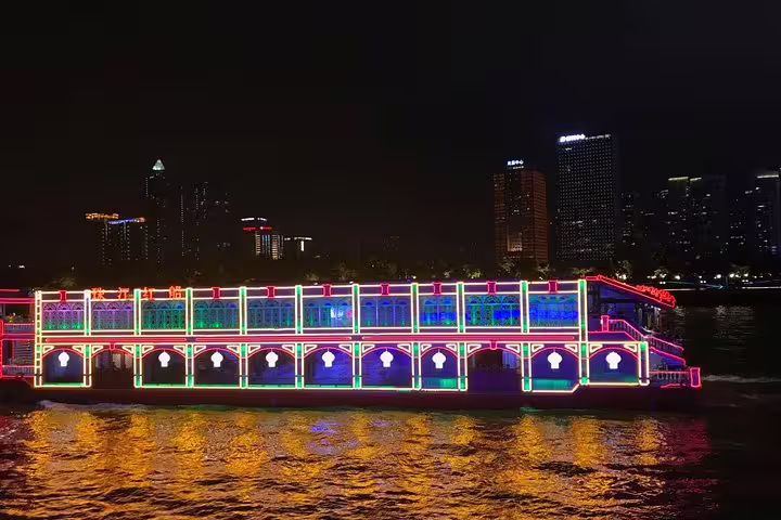 Vibrant illuminated cruise boat on Pearl River at night, highlighting the colorful nightlife of Guangzhou cityscape.