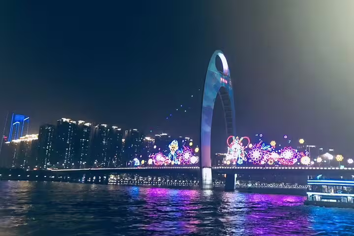 Colorful night view of lit-up Guangzhou bridge over the Pearl River, perfect for a scenic evening cruise experience.