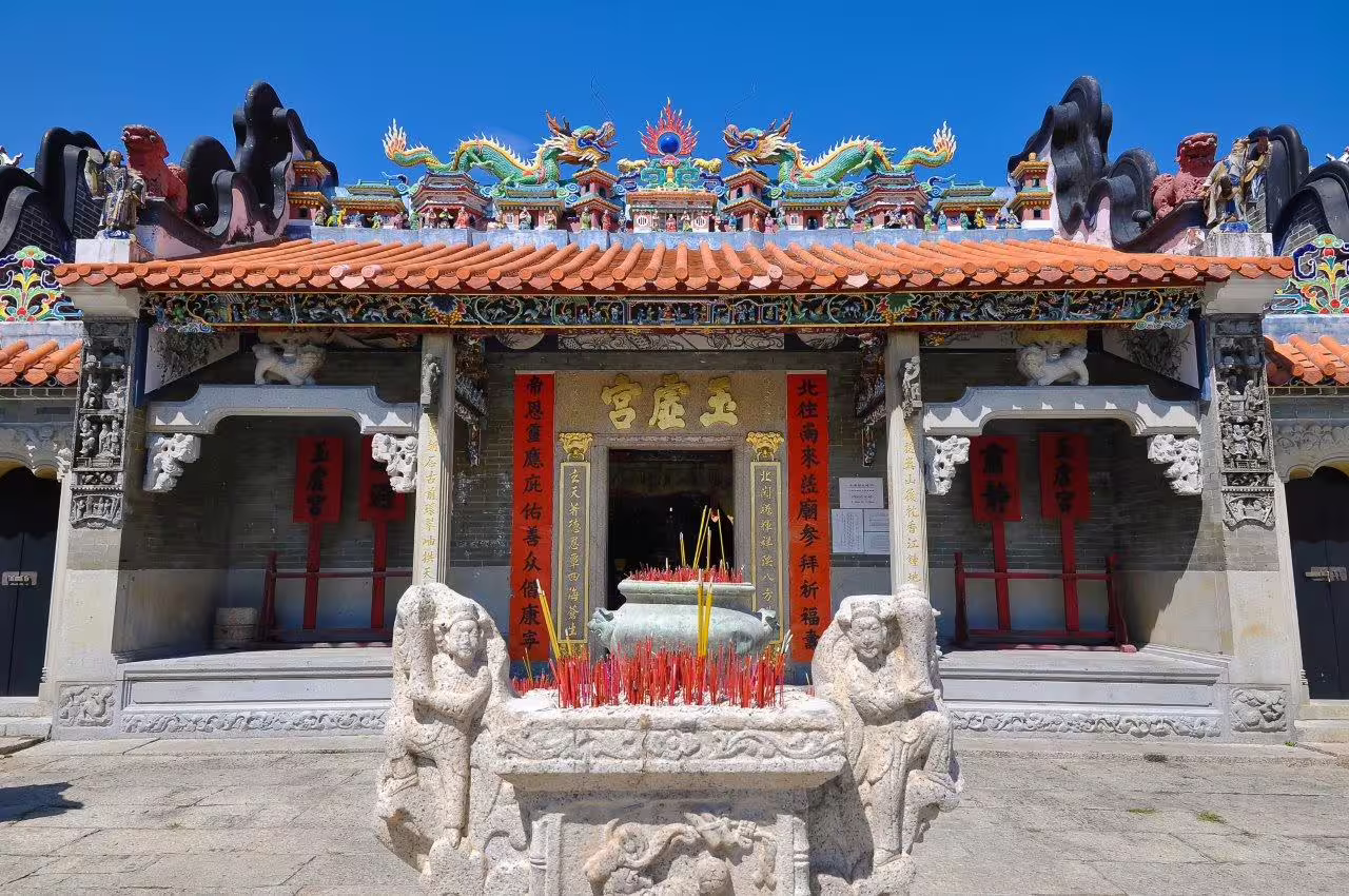 Colorful traditional Chinese temple facade with ornate details and incense, perfect for Guangzhou cultural tours.