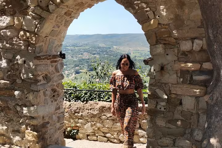 Guest walks through stone arch lookout in Provence on a private chauffeur-driven sightseeing day trip