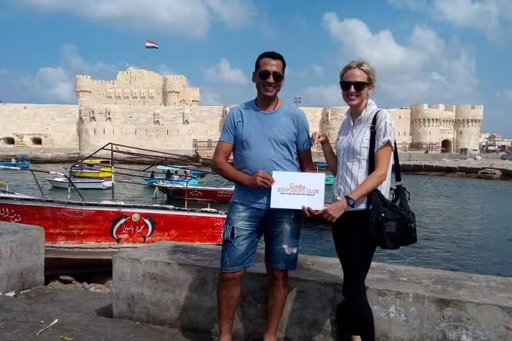 Guests posing by Qaitbay Citadel waterfront in Alexandria, memorable stop on private Cairo to Alexandria day tour
