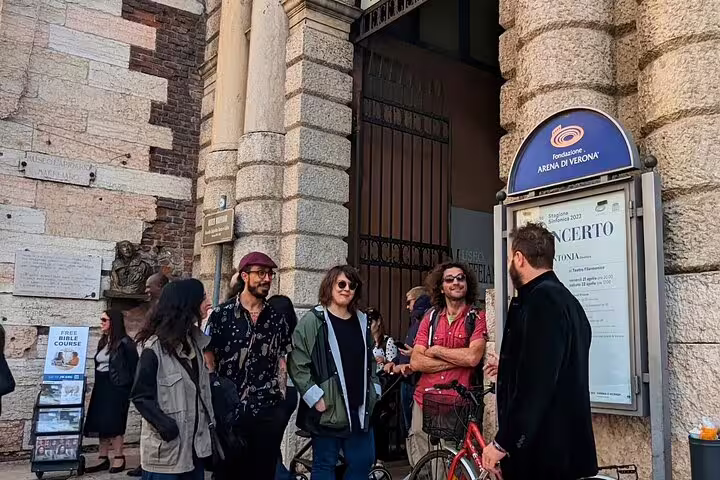 Local guide meeting group outside Verona Arena entrance, starting guided food tour with wine tasting
