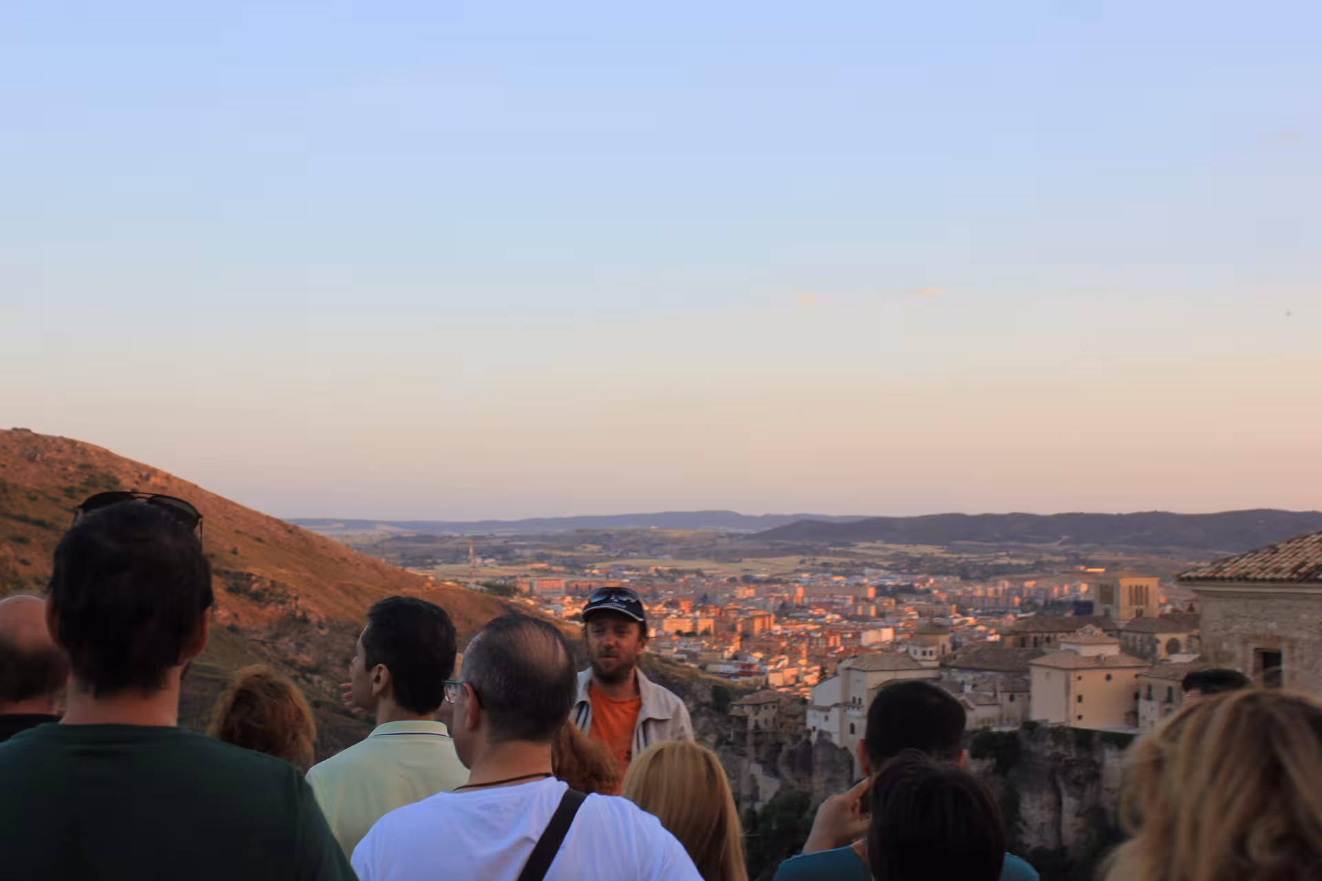Grupo con guía contemplando el atardecer sobre el casco histórico de Cuenca en visita guiada ciudad medieval