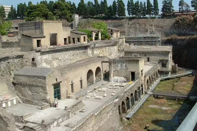 Guided tour of ancient ruins near Pompeii showcasing stone arches, excavated villas and dramatic volcanic cliffs in Campania