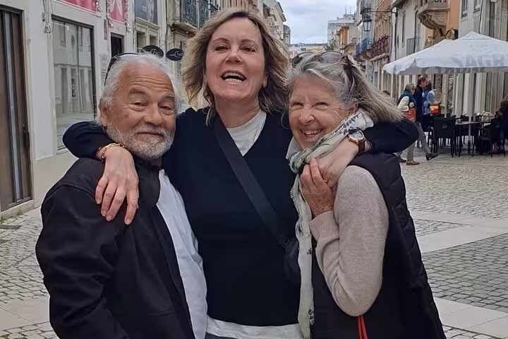 Happy tourists enjoy a guided tour in Tomar, exploring charming streets with a local guide.