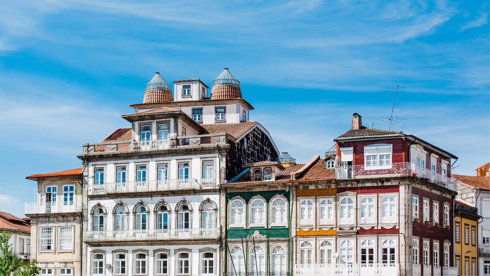 Colorful traditional Portuguese architecture under a clear blue sky in Guimarães, highlighting cultural heritage.