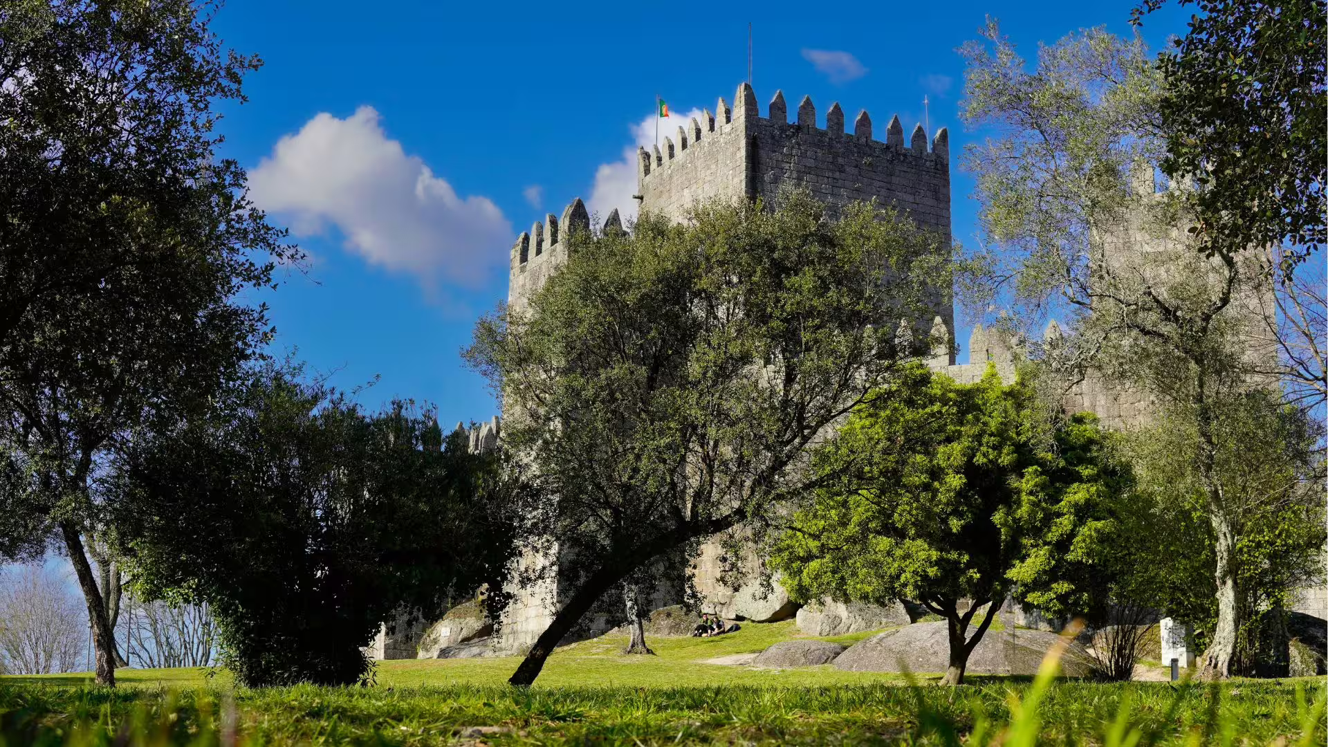 Image of Guimarães Castle surrounded by green vegetation, part of Cooltour Oporto's Braga & Guimaraes Tour