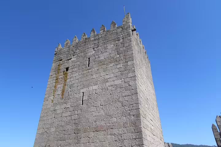 Discover the historic tower of Guimarães Castle on a private half-day tour from Porto, showcasing medieval architecture.