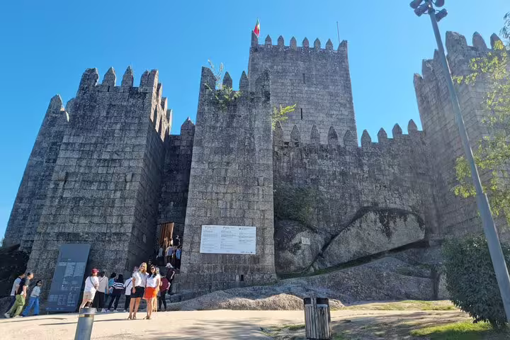 Guimarães Castle under clear blue sky, a key landmark on the Braga and Guimarães private historic tour from Porto.