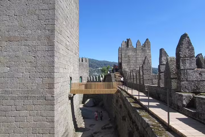 Explore the ancient stone walls of Guimarães Castle on a half-day private tour from Porto, offering rich history and scenic views.