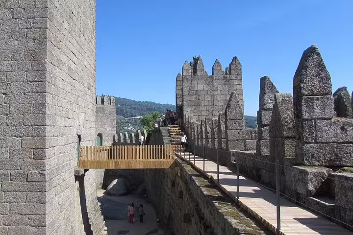 Explore the ancient stone walls and battlements of Guimarães Castle on a private half-day tour from Porto.