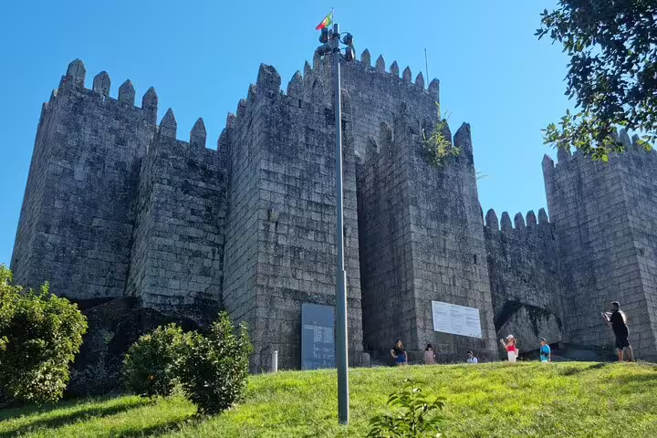 Impressive Guimarães Castle tower, a key landmark, set against a clear blue sky during a historic tour.