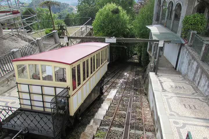 Charming vintage funicular railway in Guimarães surrounded by lush greenery, a highlight of the Porto day trip.