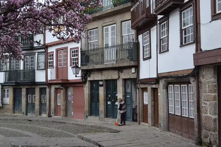 Charming historic buildings in Guimarães with blooming trees, ideal for a half-day private tour from Porto.