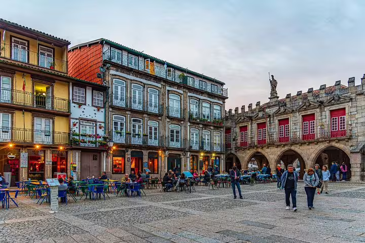 Charming square in Guimarães with colorful historic buildings and outdoor cafes, ideal for a half-day tour from Porto.