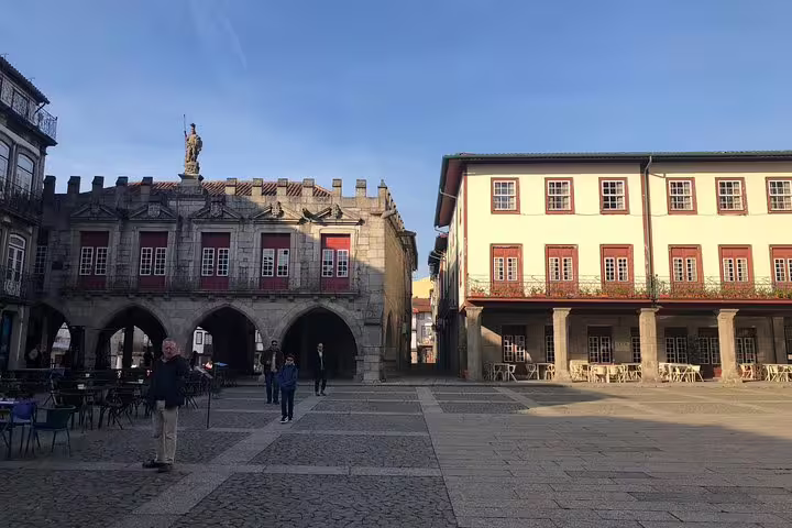 Stroll through the charming squares of Guimarães featuring medieval architecture, part of a full-day small group tour.