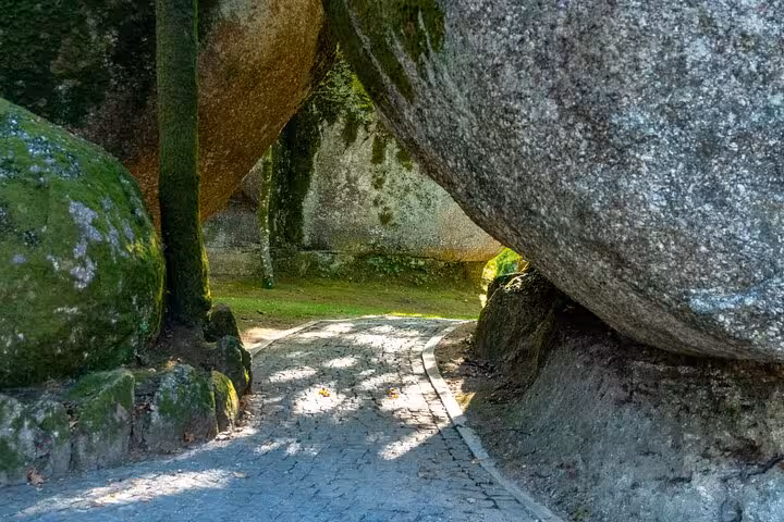 Scenic path through moss-covered boulders in Guimarães, Portugal, showcasing natural beauty on a private full-day tour.
