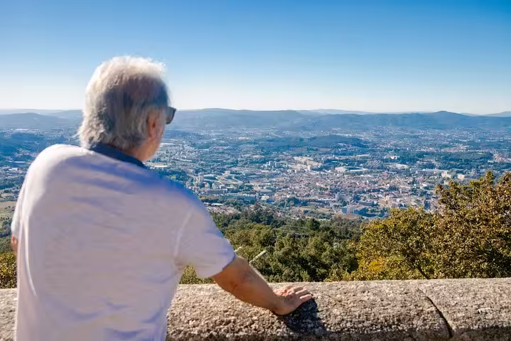 Man enjoying panoramic view over Guimarães from a scenic overlook, highlighting Portugal's rich landscapes on a half-day tour.
