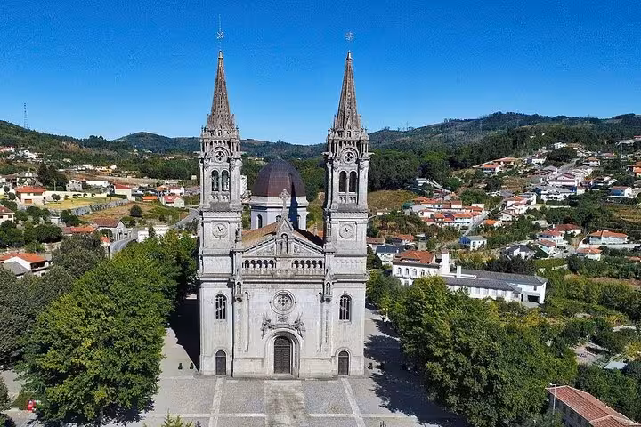 Aerial view of the majestic church of São Torcato, surrounded by lush greenery in Guimarães, Portugal.