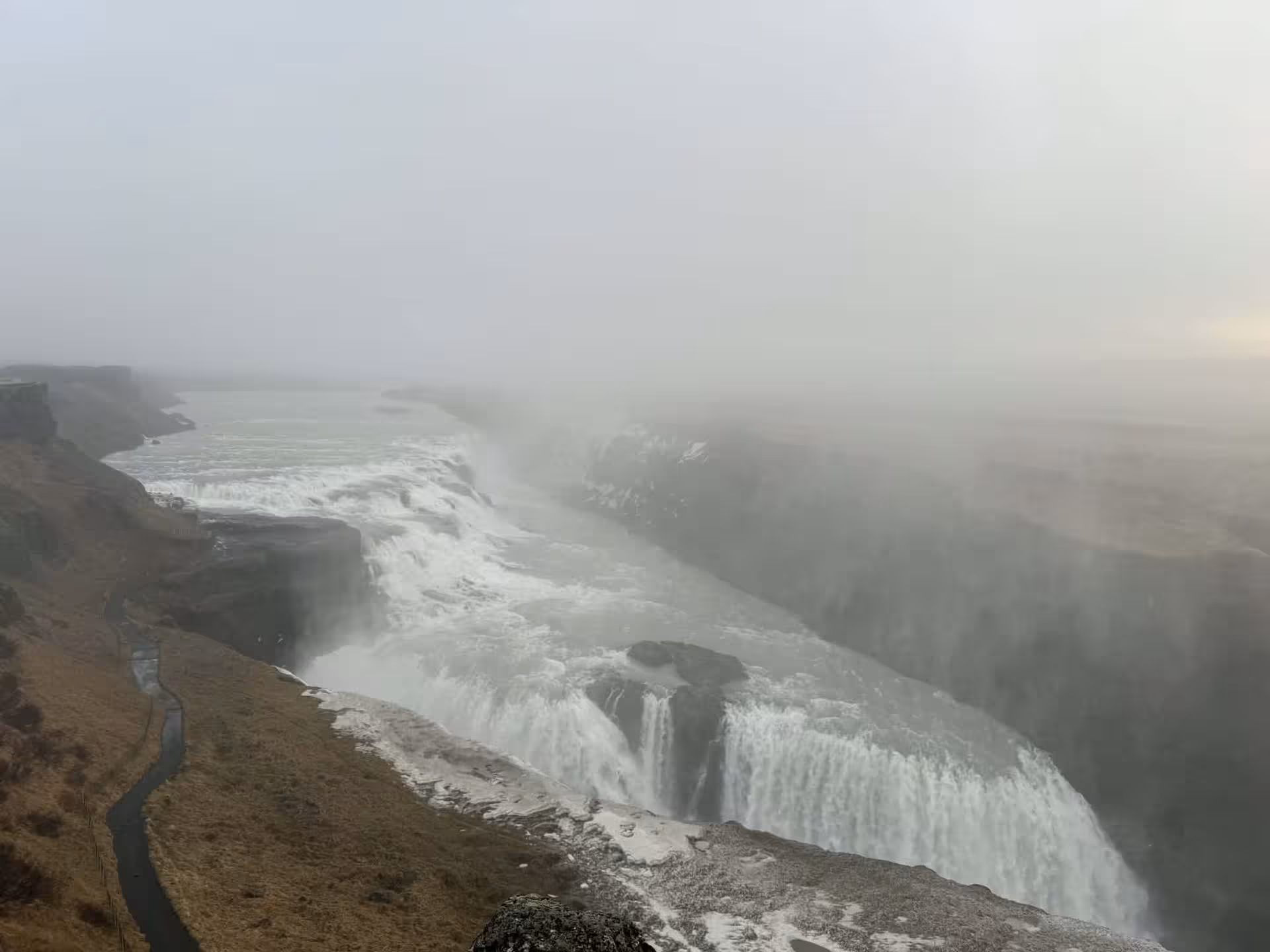 Misty Gullfoss waterfall plunging into canyon, highlight stop on Grand Golden Circle day tour from Reykjavik