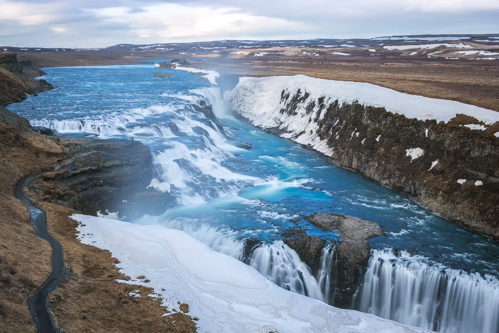Gullfoss Waterfall cascading through snowy cliffs, a highlight of the Northern Lights Stopover in Reykjavík tour.