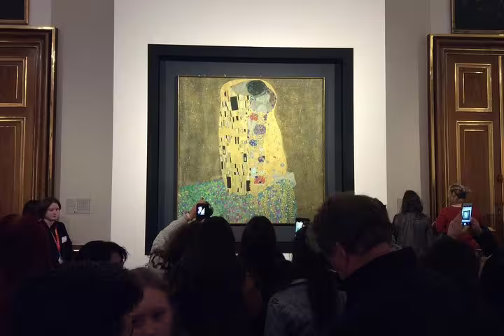 Visitors admire Gustav Klimt's famous painting 'The Kiss' at the Belvedere Museum, a highlight of Viennese art tours.