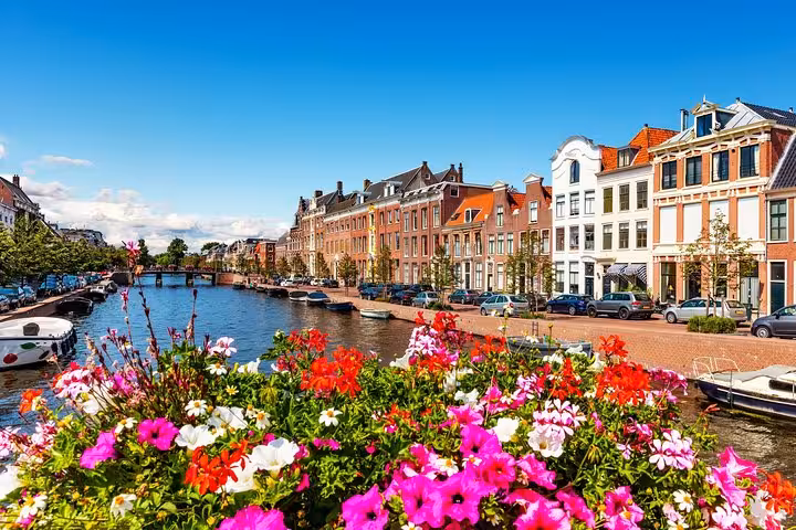 Colorful canal houses and flower-lined waterfront seen on Highlight Bike Tours Haarlem cycling route